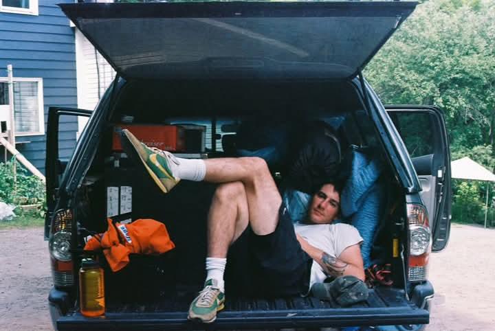 Alex Nunes sitting casually in the back of a van.